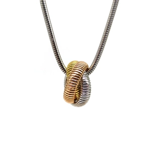 Macro shot of tricolor interlocking rings with threaded texture on a silver snake chain