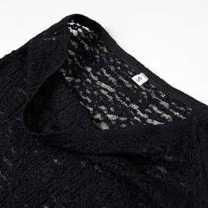 Détail du col en dentelle noire avec motifs floraux et étiquette de taille S