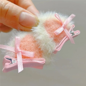 Close-up of pink and white plush heart hair clips with ribbon bows for girls