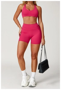 Dettaglio del set yoga rosa con reggiseno sportivo vogatore e pantaloncini alti