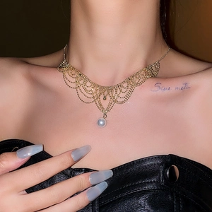 Detailed view of a lace-style woven pearl necklace with a central white pearl pendant