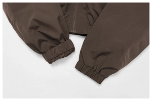 Detail of elastic cuffs and smooth metal zipper on this dark brown windproof jacket