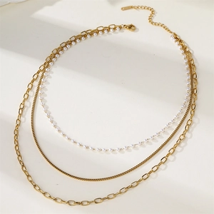 Detailed macro view of triple-layered 18K gold plated necklace with pearls and lobster clasp