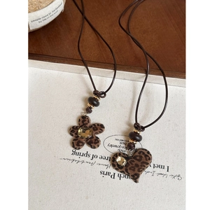 Detailed close-up of leopard print heart and flower resin pendants on woven cord