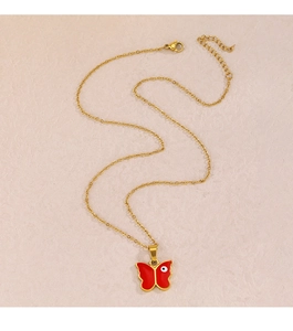 Detail der Goldkette mit rotem Schmetterling-Evil-Eye-Anhänger auf strukturiertem Grund