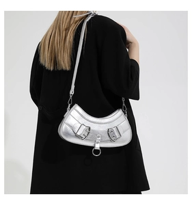 Silver metallic crescent bag detail featuring belt buckles and moon shape on black blazer