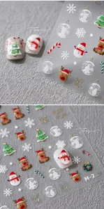 Macro view of 3D embossed Christmas nail stickers featuring snowman and reindeer