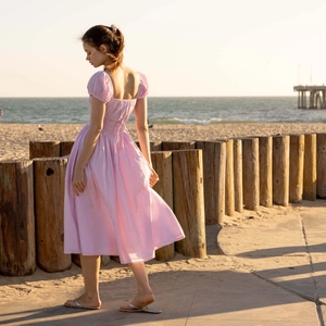 Vestido midi rosa de rayas con escote cuadrado y mangas abullonadas en la playa