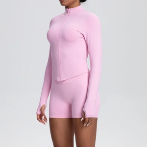 Détail d'un ensemble de yoga rose avec col montant, zip et passe-pouces sur tissu tricoté