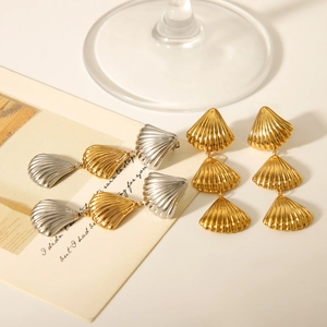 Detail view of layered shell pendant earrings in polished gold and silver finish