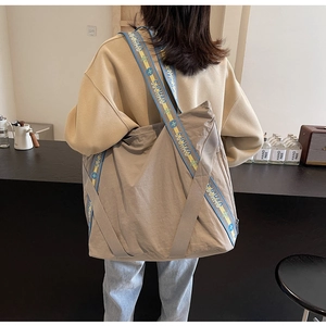 Détail du sac fourre-tout en nylon kaki avec large bandoulière imprimée et grand volume
