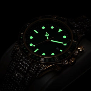 Macro shot of gold diamond-studded watch featuring black dial and green luminous markers