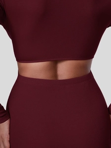Detalle de la tela de punto acanalado burdeos y corte en la cintura de un vestido ceñido