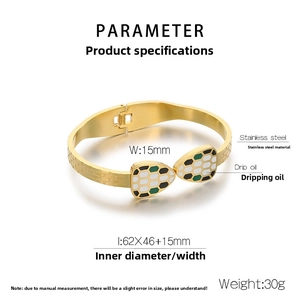 Golden stainless steel bangle featuring white and green enamel snake heads with drip oil detail