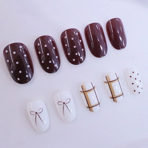 Short oval press-on nails with brown dots, bows, and plaid patterns in wine red and white