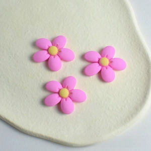 Close-up of pink resin peach blossom charms for DIY hair accessories and crafts