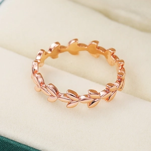 Detailopname van roségouden olijfbladring op een zachte juwelendoosvoering