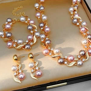 Détail macro d'une parure vintage dorée avec perles roses et cristaux en coffret