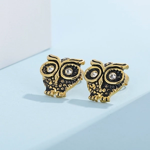 Vue macro de boucles d'oreilles hibou bicolores avec des yeux en strass brillants