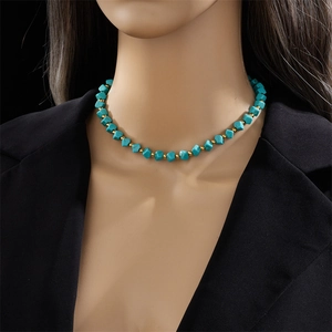 Collana di perle turchesi vintage francese con accenti dorati indossata su un blazer nero