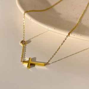 Minimalist gold titanium steel cross necklace with a sparkling cubic zirconia stone