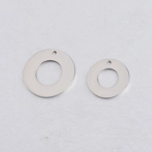 Macro view of two polished stainless steel circular pendants with smooth mirrored finish