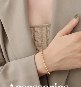 Polished 18K gold plated steel bead bracelet shown on wrist in luxury minimalist style