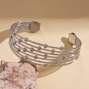 Macro view of five-layered silver beaded cuff bracelet with faceted beads on stone