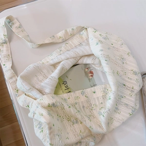Detailed top view of a white floral lace tote bag with blue watercolor patterns