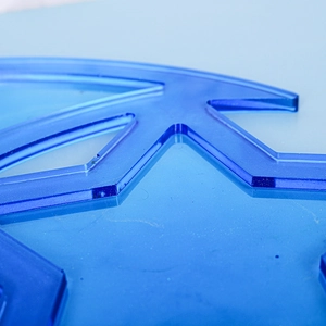 Macro shot of blue glitter translucent acrylic with laser-cut geometric star and moon edges
