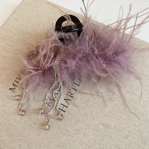 Detail of lavender feather hair claw clip with sparkling rhinestone fringe tassels