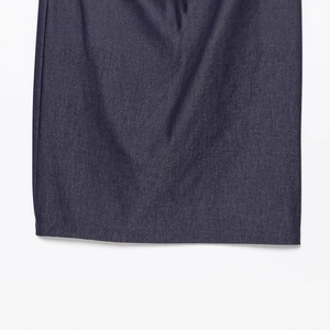 Nahaufnahme des Saums eines dunkelvioletten Midikleids mit feiner Stoffstruktur und Naht