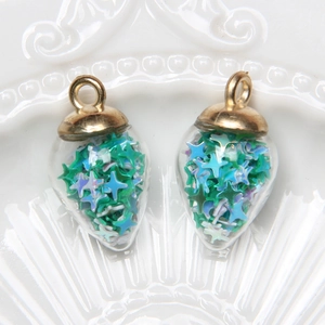 Detail of drop-shaped glass pendants with blue green star sequins and gold metal caps