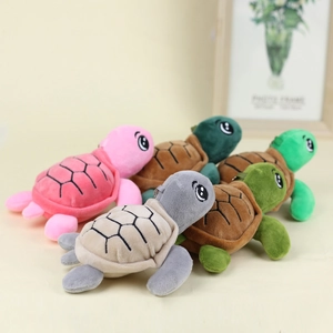 Close-up of five colorful plush turtle keychains in pink, grey, brown, and green tones