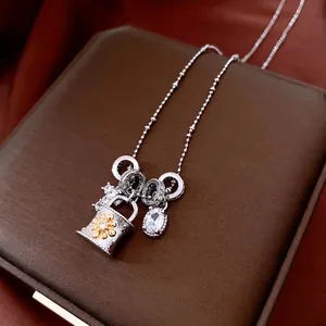 Collana con croce di zirconi regolabile e ciondolo a borsa su scatola porta gioielli