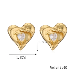 Macro detail of heart-shaped earrings with 1.8cm molten gold texture and central zircon
