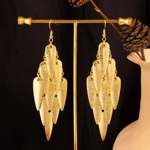 Macro detail of gold-finish multi-layered leaf earrings with matte metallic texture