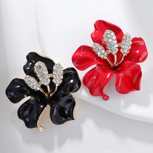 Detailed macro view of vintage flower brooches with red and black enamel and rhinestones
