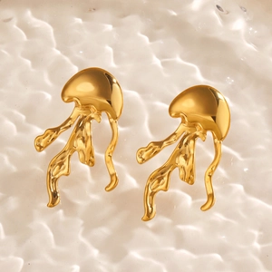 Golden jellyfish stud earrings with metallic luster on ocean wave textured background