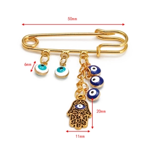 Detailed view showing the 50mm gold Hamsa pin dimensions with 6mm evil eye charms