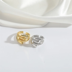 Detailed view of layered nail design open rings in polished gold and silver finishes