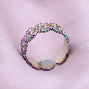 Macro view of adjustable iridescent 304 stainless steel ring with daisy floral pattern