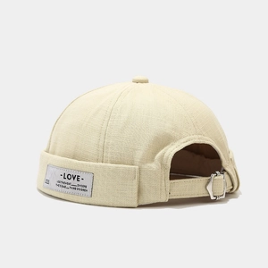 Beige cotton brimless docker cap with adjustable strap and vintage label for men and women