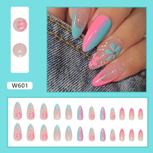Detail of almond press-on nails with blue-pink gradient and glitter floral patterns