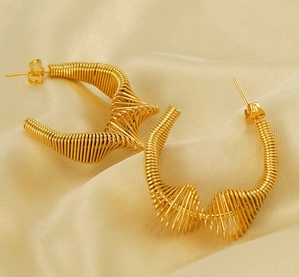 Detailed view of golden spring spiral hoop earrings with intricate metal wire texture