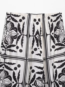 Detail van de elastische taille op zwart-witte katoen-linnen broek met print