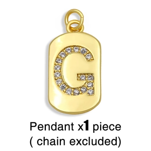 Close-up of gold rectangular pendant with pavé-set letter G and soft lighting detail