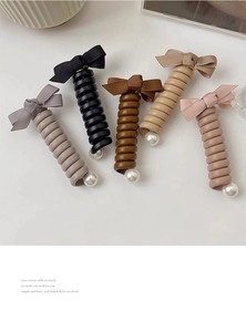 Détail de chouchous spirales avec nœuds en tissu et perles en cinq couleurs élégantes