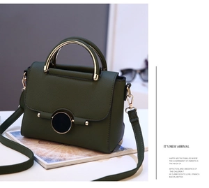 Detail of forest green pebbled leather handbag with gold arc handle and magnetic clasp