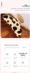 Gros plan d'une pince à cheveux motif vache sur des cheveux longs bruns